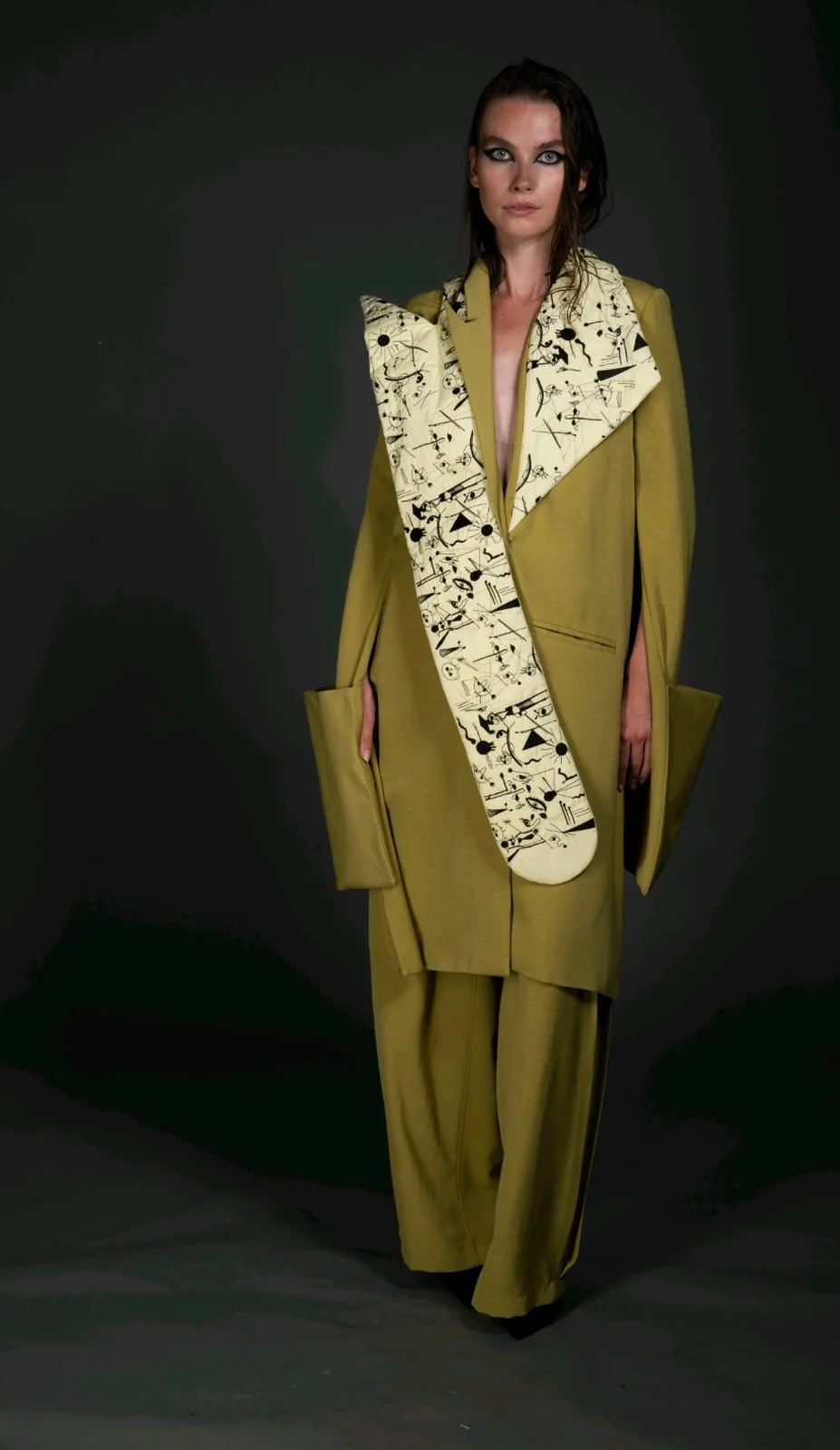 Front view — the full-length doodle-print panel centred over the coat and trousers.