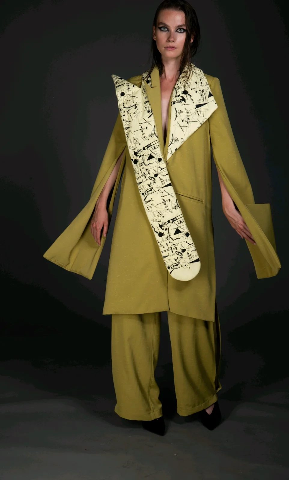 Front view — arms out, showing the slit sleeves and the free-flowing panels of the ensemble.