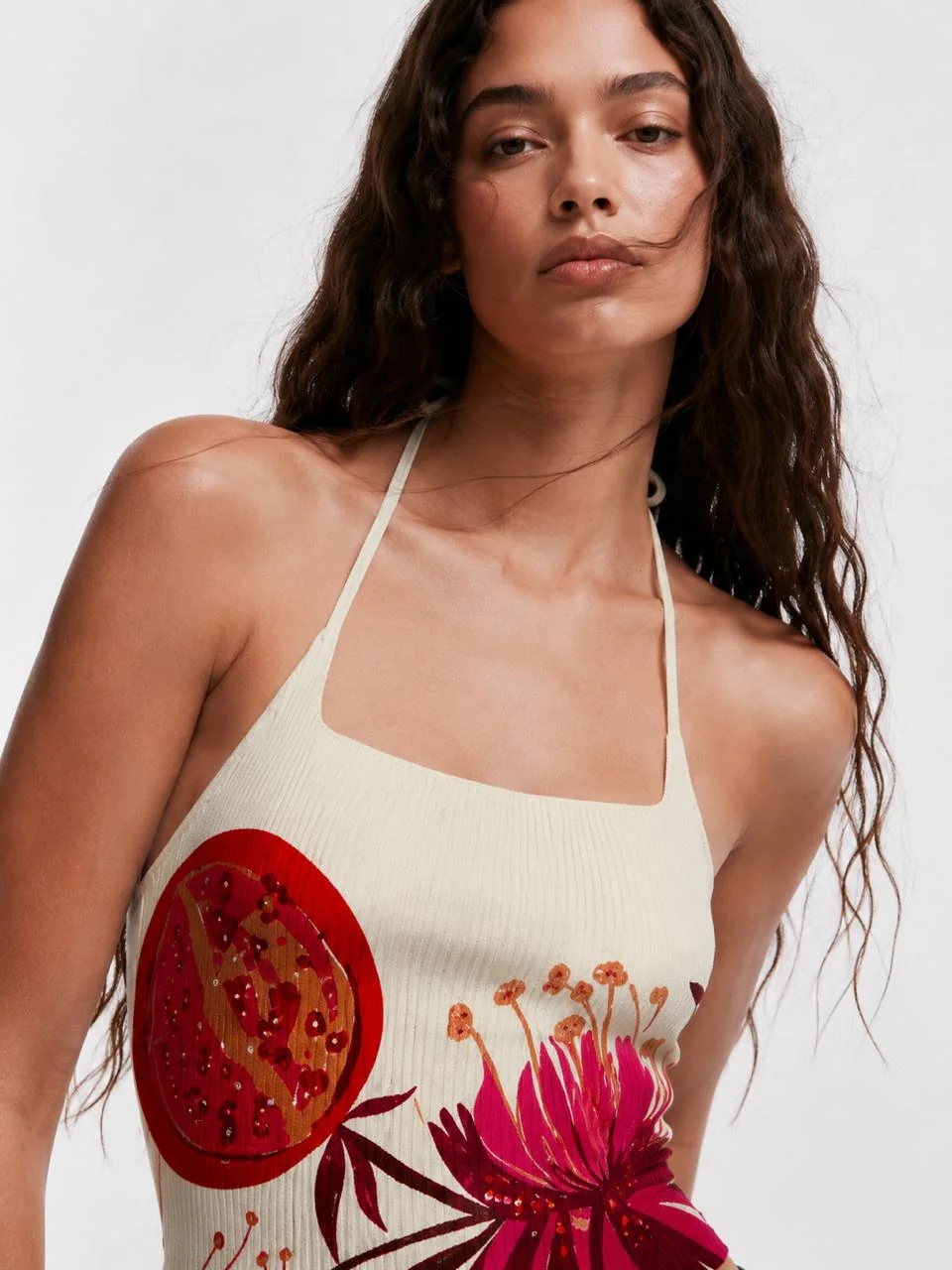 Close-up of the Malibu bloom top — sequinned pomegranate and blooms on the cream rib knit.